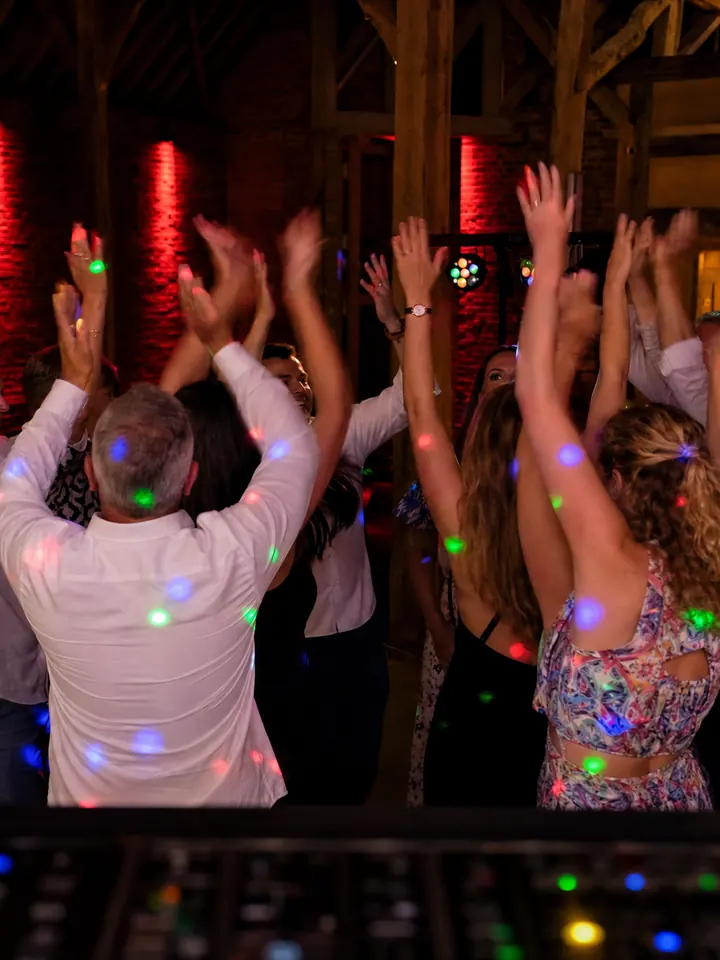 Volle dansvloer in een feestschuur, gezien vanaf de DJ-booth